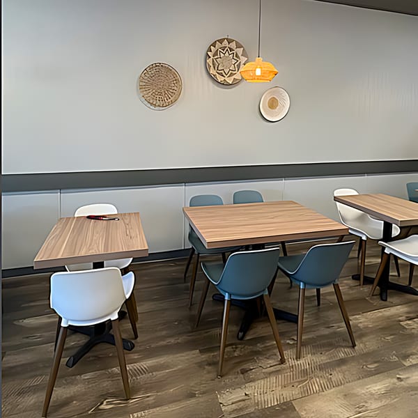 Interior of Pho Time restaurant with light wood tables, modern chairs, and decorative wall hangings.