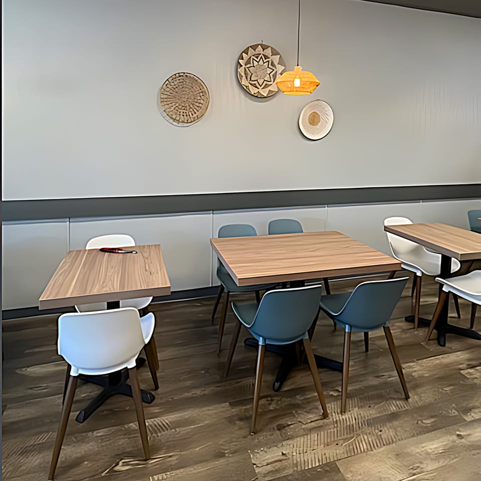 Interior of Pho Time restaurant with light wood tables, modern chairs, and decorative wall hangings.
