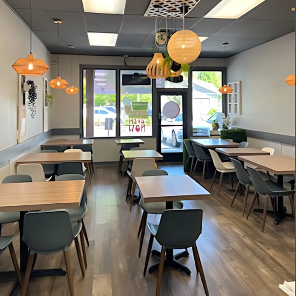Interior of Pho Time restaurant with empty tables and chairs, and decorative hanging lights.
